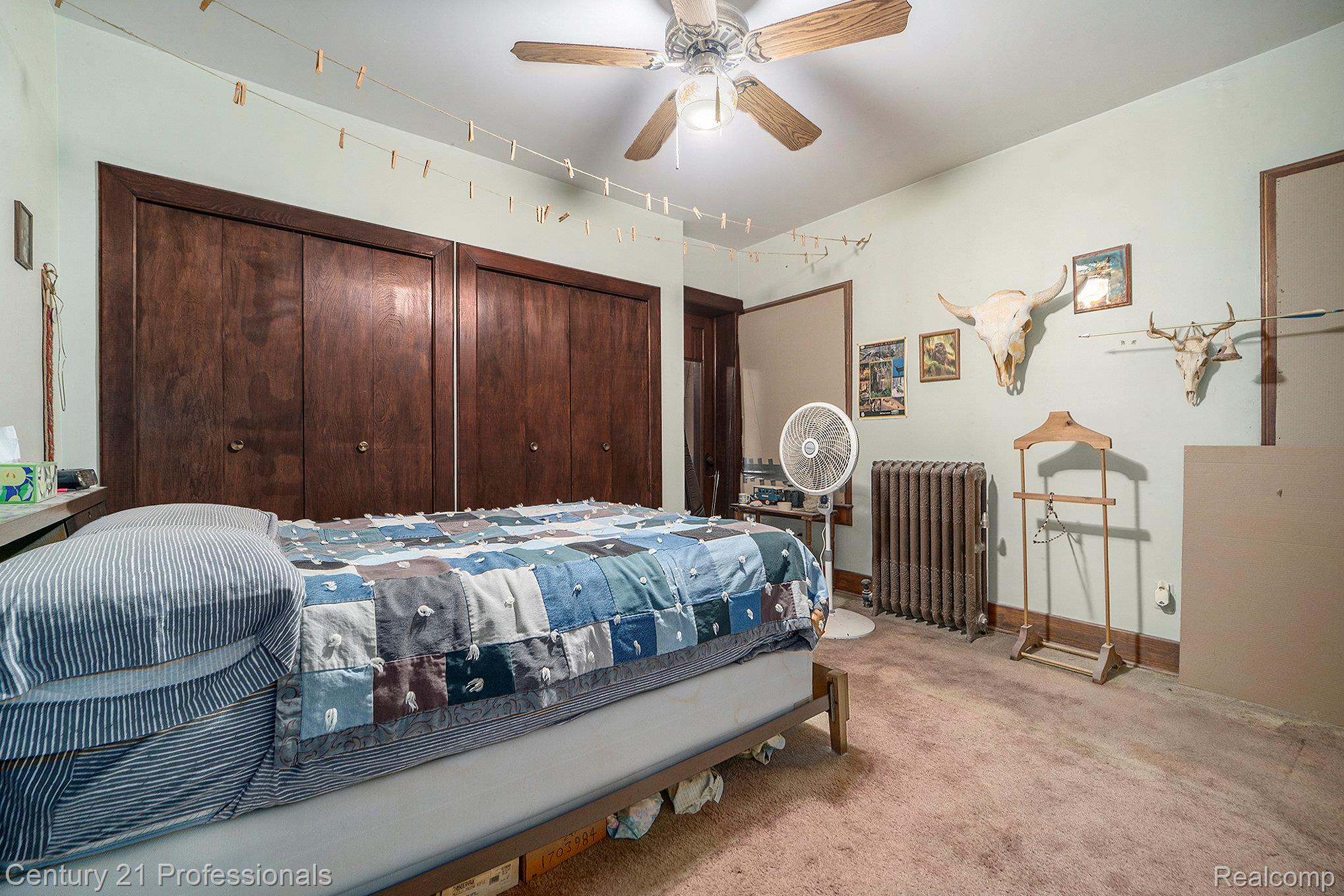 428 East Street Rochester, MI 48307 - Photo 13 of 30 Carpeted bedroom with radiator heating unit, multiple closets, and ceiling fan
