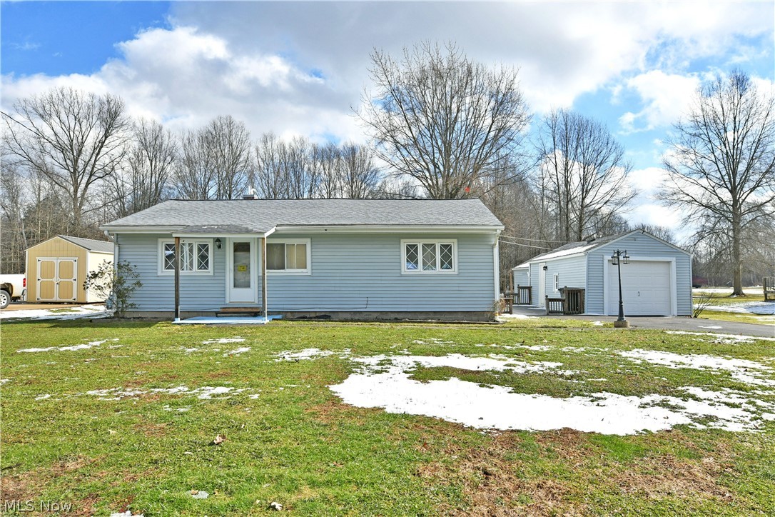 878 Ridge Road Vienna, OH 44473 - Photo 1 of 50 View of front facade featuring a shed, a front lawn, a garage, and a patio area