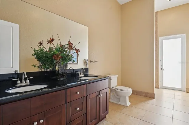 a bathroom with a double vanity sink a toilet and a mirror