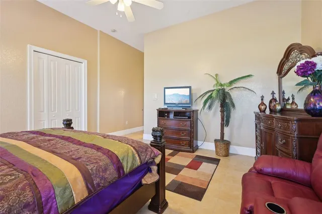 a spacious bedroom with a bed a chandelier and a couch