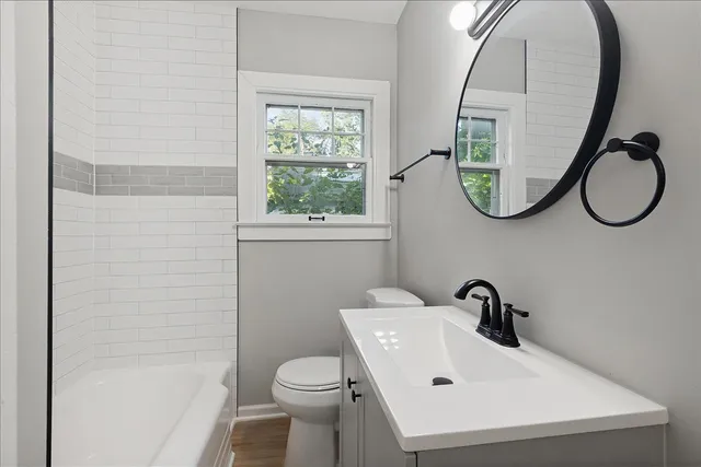 a bathroom with a sink a toilet and a mirror