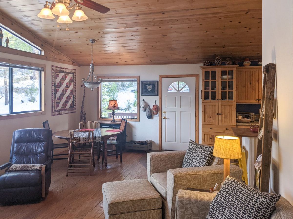 52790 Idyllmont Road Idyllwild, CA 92549 - Photo 10 of 65 a living room with furniture a chandelier and a dining table