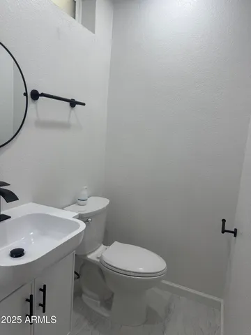 a white toilet sitting next to a bathroom sink