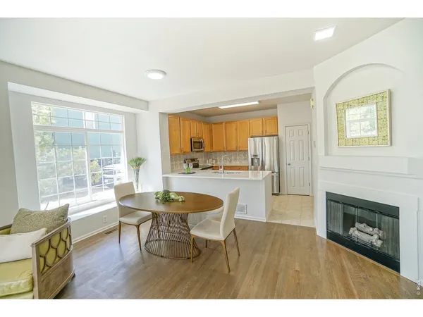 a living room with furniture a fireplace and a large window