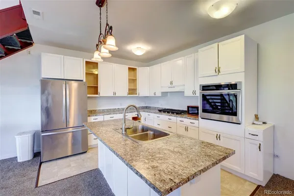 a kitchen with stainless steel appliances granite countertop a sink stove and refrigerator
