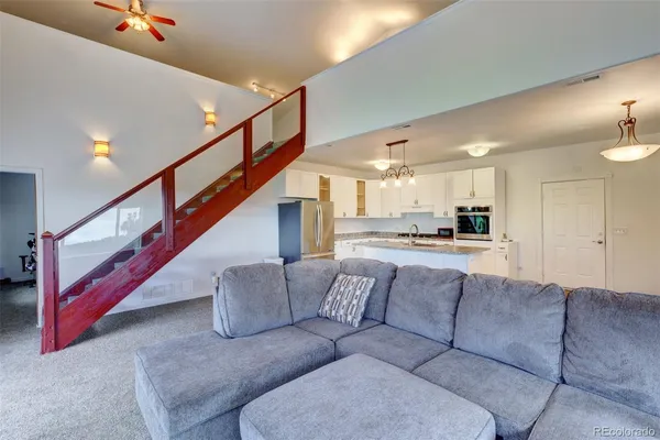 a living room with furniture and stairs