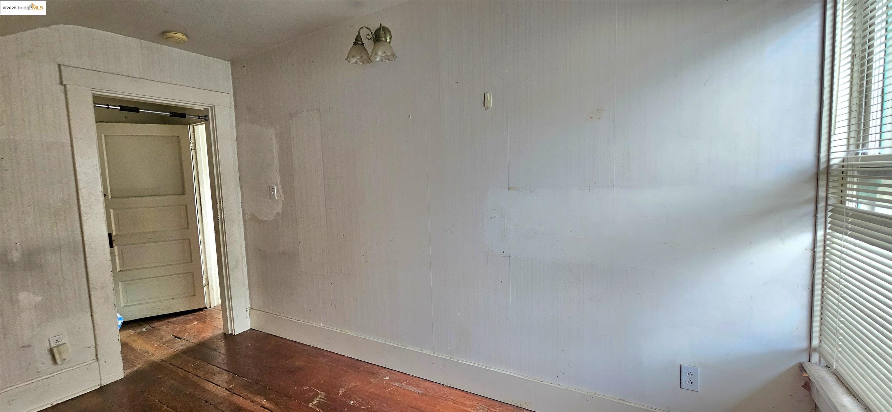 2308 Parker Street Berkeley, CA 94704 - Photo 6 of 17 an empty room with wooden floor door and windows