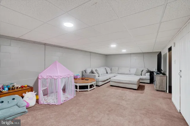 a living room with furniture and a baby crib