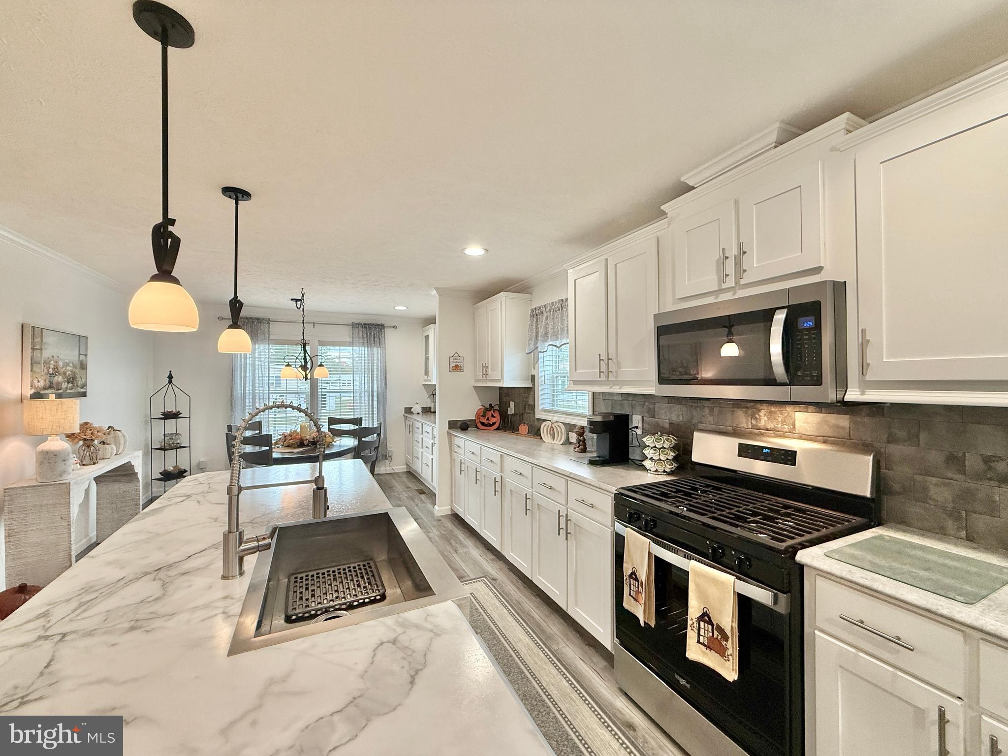 768 East Garden Road, Unit 7 Vineland, NJ 08360 - Photo 19 of 37 a large kitchen with stainless steel appliances granite countertop a stove a sink dishwasher and a microwave with wooden floor