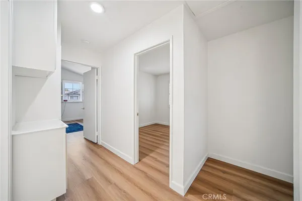 a view of a hallway with wooden floor and furniture