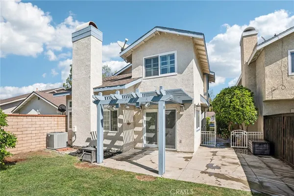 a view of a patio with a table chairs potted plants and palm trees