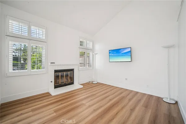 a view of empty room with wooden floor and fireplace