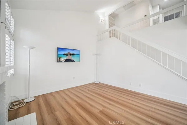 a view of a room with wooden floor and white walls