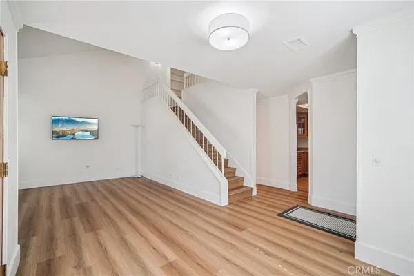 a view of an empty room with wooden floor