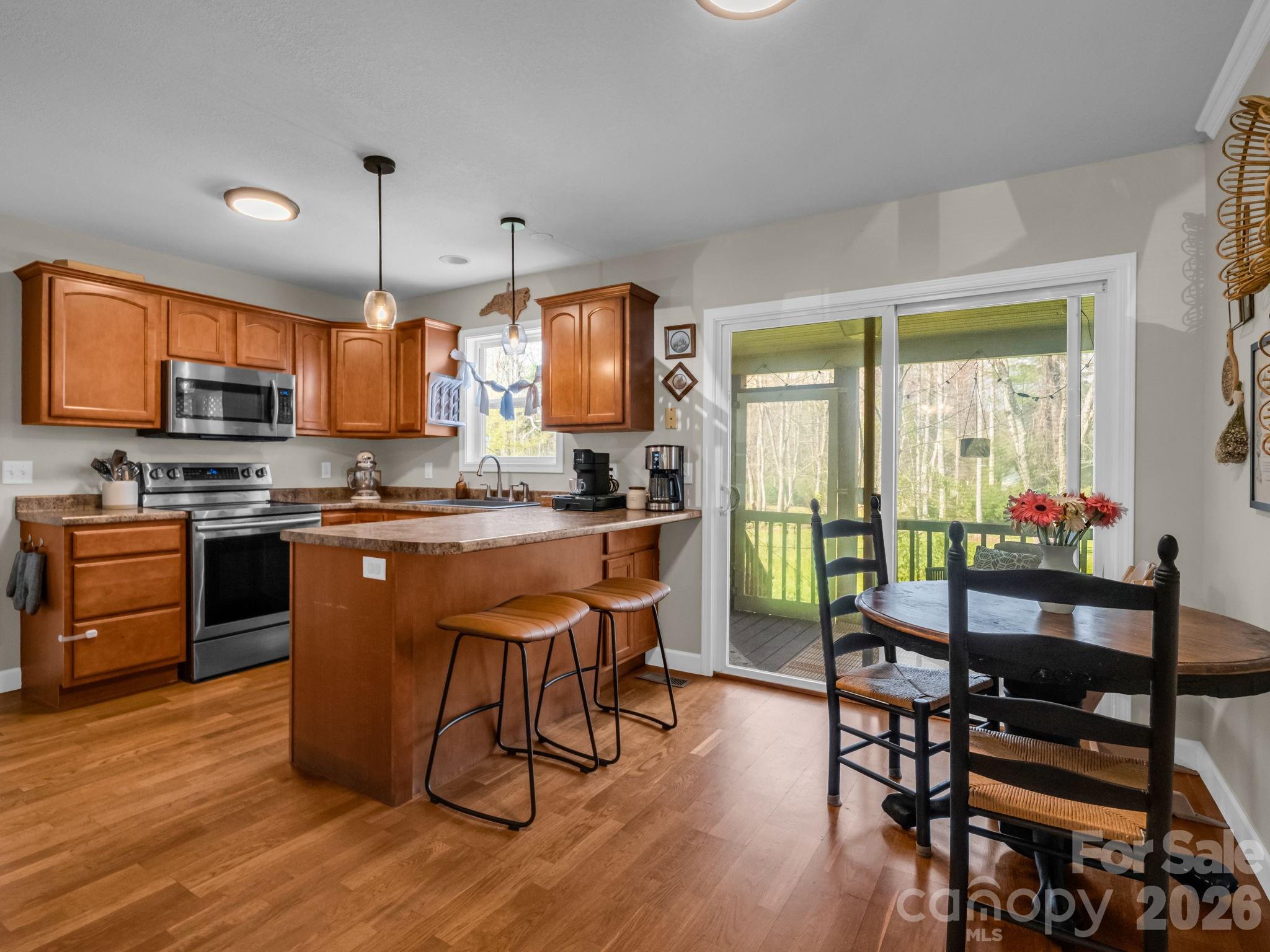 22 Macks Way Hendersonville, NC 28739 - Photo 10 of 42 a kitchen with stainless steel appliances granite countertop a stove a refrigerator a kitchen island a dining table and chairs with wooden floor