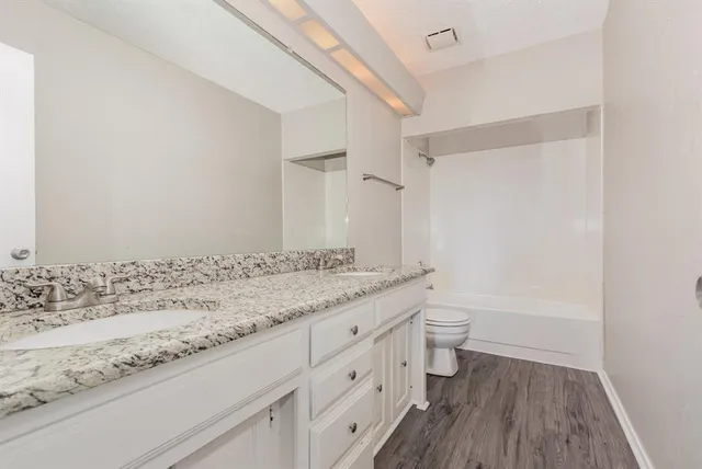 a bathroom with a granite countertop sink toilet and shower
