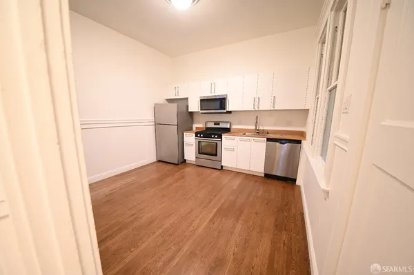 a kitchen with a refrigerator and a stove top oven
