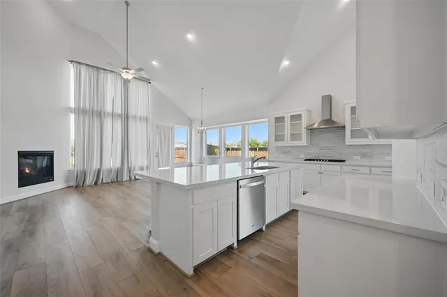 a kitchen with granite countertop a sink cabinets and wooden floor