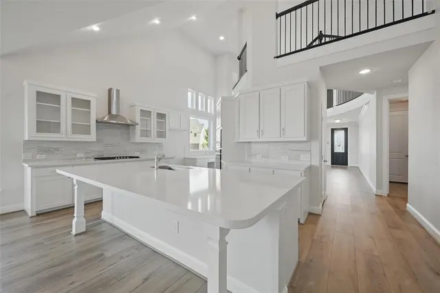 a large kitchen with stainless steel appliances granite countertop a lot of counter space and wooden floors