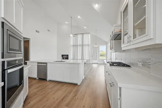 a kitchen with a sink a counter top space stainless steel appliances and cabinets