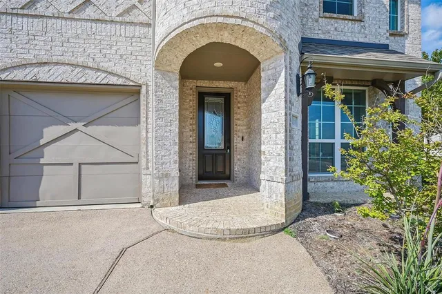 a view of a brick house with potted plants