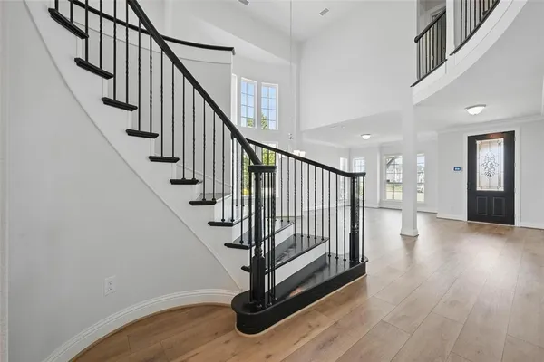 a view of staircase with wooden floor and white walls