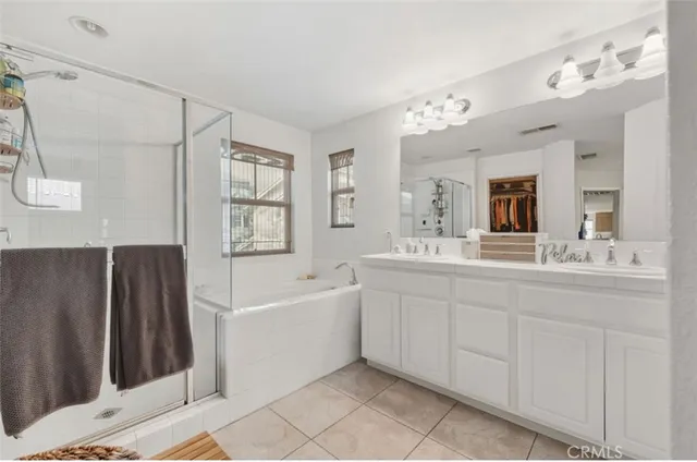a spacious bathroom with a tub sink and mirror