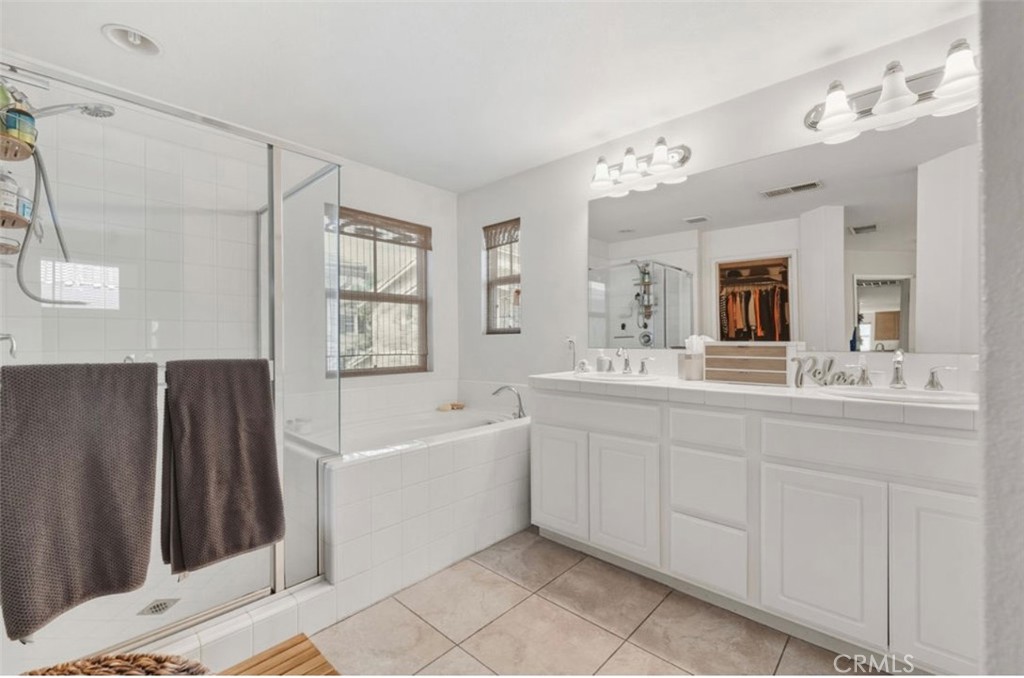 10326 Sparkling Drive, Unit 1 Rancho Cucamonga, CA 91730 - Photo 21 of 34 a spacious bathroom with a tub sink and mirror