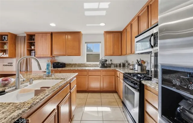 a kitchen with stainless steel appliances granite countertop a sink stove and cabinets