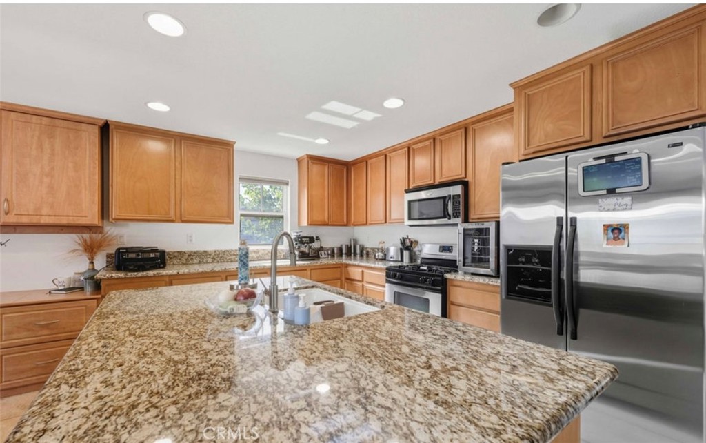 10326 Sparkling Drive, Unit 1 Rancho Cucamonga, CA 91730 - Photo 9 of 34 a kitchen with stainless steel appliances granite countertop a sink refrigerator and cabinets