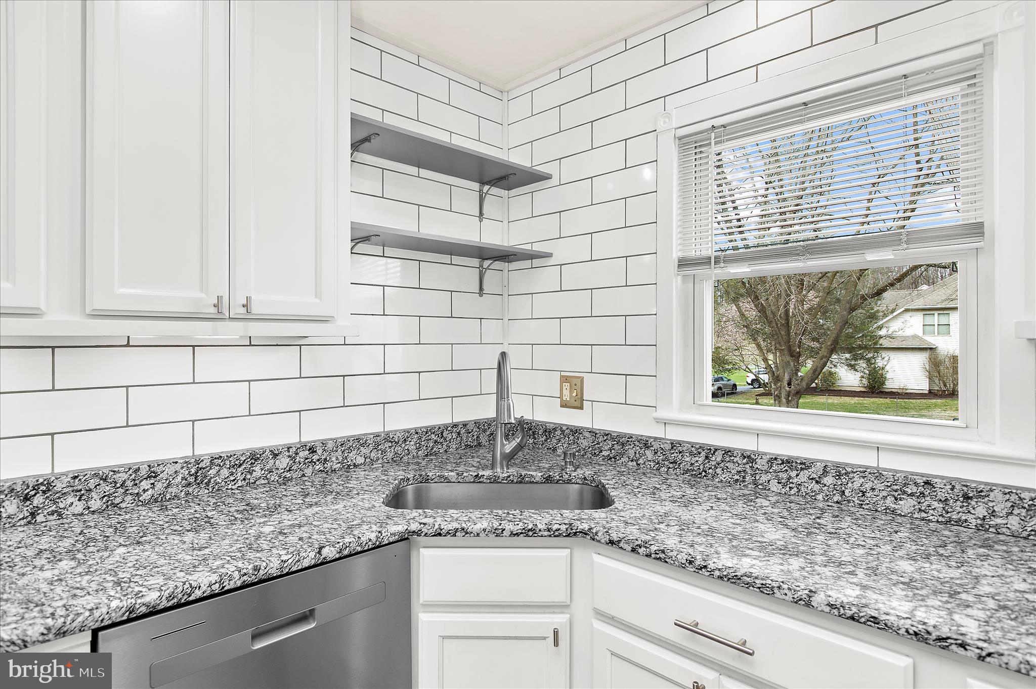 9140 Vollmerhausen Road Savage, MD 20794 - Photo 15 of 49 a kitchen with granite countertop white cabinets and a window