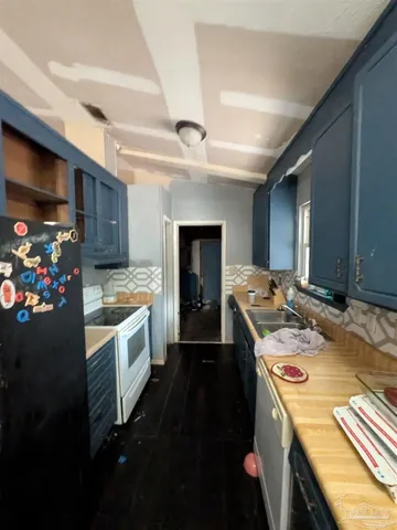 a kitchen with stainless steel appliances a refrigerator sink and cabinets