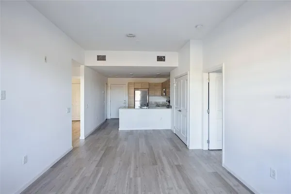 a view of a hallway with wooden floor and a bathroom