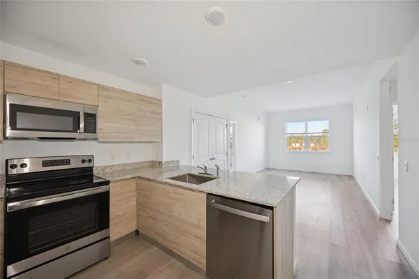 a kitchen with a sink stove and microwave