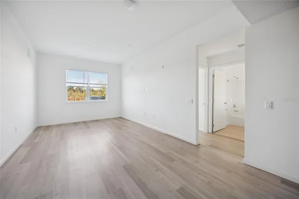 an empty room with a window and wooden floor