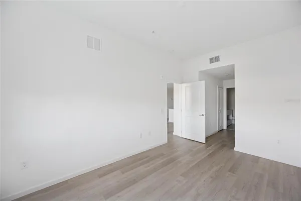 a view of an empty room with wooden floor