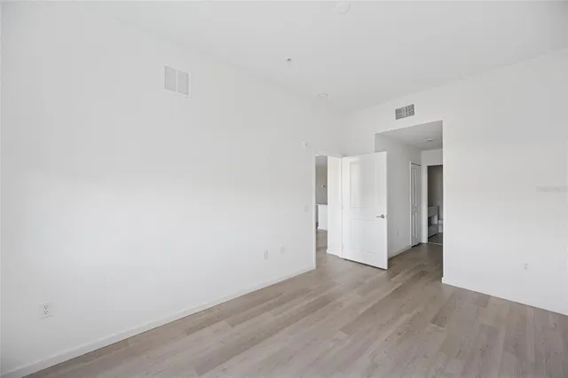 a view of an empty room with wooden floor