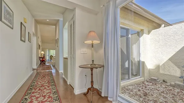a view of a hallway with wooden floor and a living room