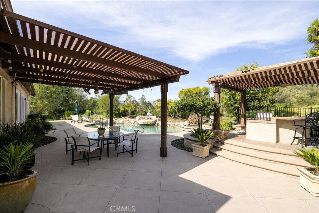 29031 Bouquet Canyon Road Silverado, CA 92676 - Photo 14 of 26 a view of a patio with table and chairs potted plants with floor to ceiling window