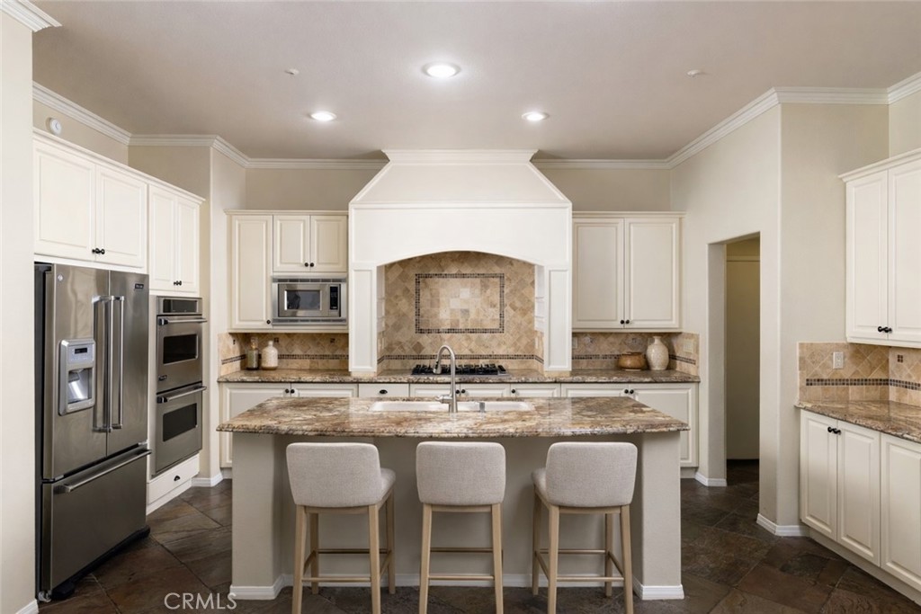 29031 Bouquet Canyon Road Silverado, CA 92676 - Photo 3 of 26 a kitchen with stainless steel appliances granite countertop a refrigerator a sink a stove a dining table and chairs