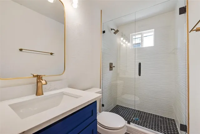 a bathroom with a sink a toilet and shower