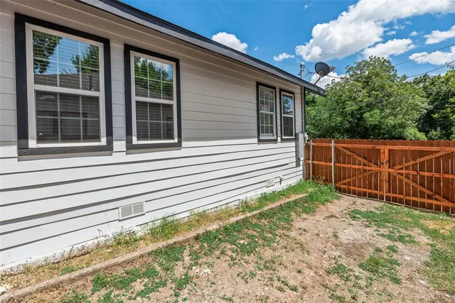 a view of a house with a yard and wooden fence