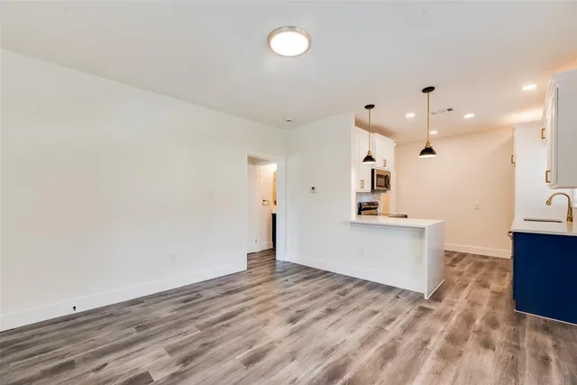 a view of a kitchen with wooden floor and a sink