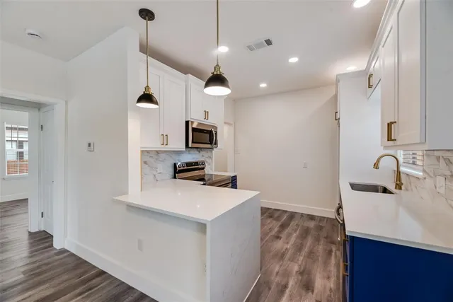 a kitchen with kitchen island a sink appliances and cabinets