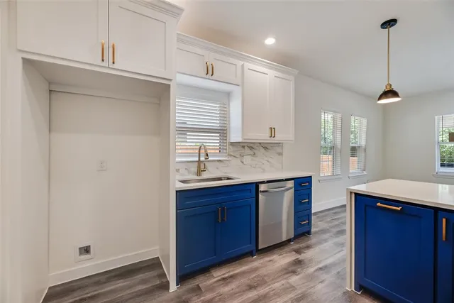 a kitchen with kitchen island granite countertop a sink cabinets and wooden floor