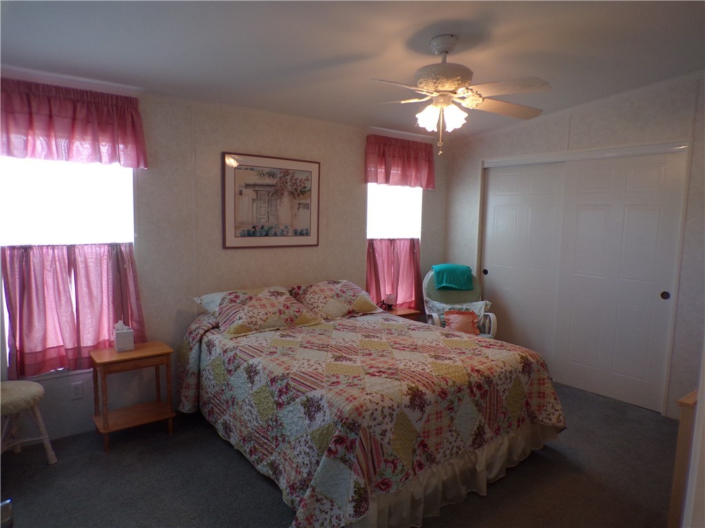 1126 Barefoot Circle Barefoot Bay, FL 32976 - Photo 11 of 16 a bedroom with a bed and a chandelier