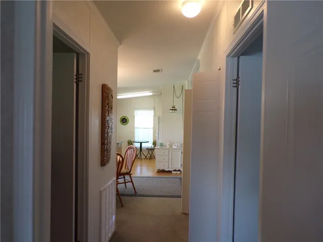 a view of a hallway with furniture and a livingroom