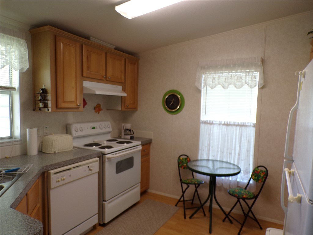 1126 Barefoot Circle Barefoot Bay, FL 32976 - Photo 4 of 16 a kitchen with a stove a sink cabinets and a window