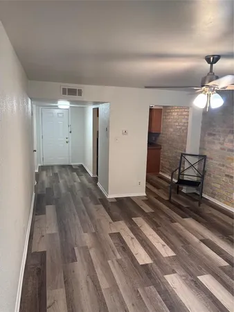 a view of empty room with wooden floor