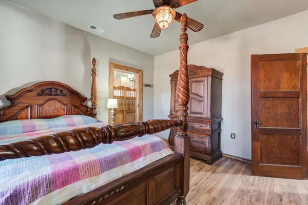 a bedroom with a bed and wooden floor
